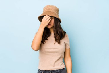 Genç, melez İspanyol bir kadın izole edilmiş, başı ağrıyor, yüzüne dokunuyor..