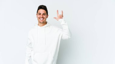 Beyaz arka planda izole edilmiş genç beyaz bir adam boynuzlarını devrim konsepti olarak gösteriyor..