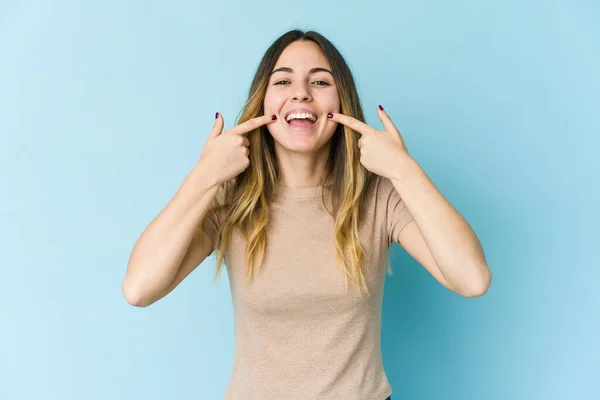 Mujer Joven Caucásica Aislada Sobre Fondo Azul Sonríe Señalando Con — Foto de Stock