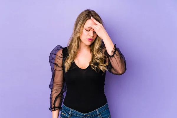 紫色の背景に頭部の痛みを感じ顔の前に触れる若い白人女性 — ストック写真