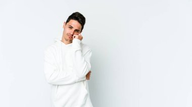 Beyaz arka planda izole edilmiş, üzgün ve dalgın hisseden genç beyaz bir adam fotokopi alanına bakıyor..