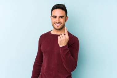 Kafkasyalı genç adam mavi arka planda izole edilmiş seni işaret ediyor sanki davet ediliyormuş gibi..