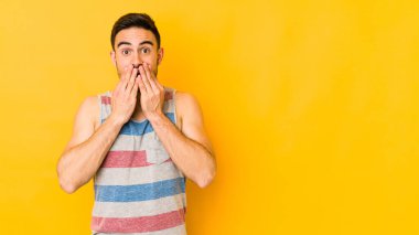 Sarı fırında izole edilmiş genç beyaz adam elleriyle ağzını kapatırken şok oldu..