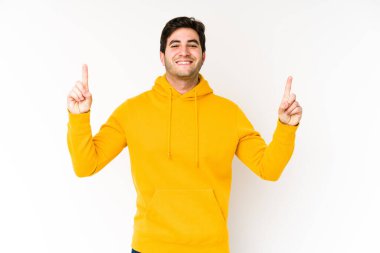 Beyaz arka planda izole genç adam iki ön parmağı da boş bir alan gösteriyor..