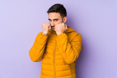 Morarmış arka planda izole olmuş genç beyaz bir adam bir tartışma yüzünden yumruk atıyor, sinirleniyor ve kavga ediyor..