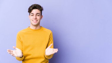 Mor arka planda izole edilmiş beyaz bir genç hoş bir yüz ifadesi sergiliyor..