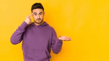 Kafkasyalı genç adam sarı fırında izole edilmiş ve elinde bir ürün var..