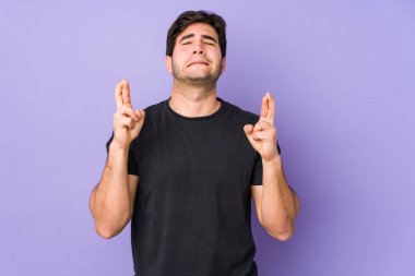 Mor arka planda izole genç adam şans dilemek için şans diliyor.