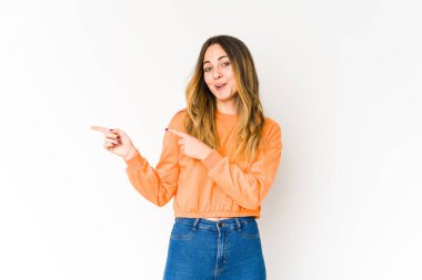 Beyaz arka planda izole edilmiş genç beyaz kadın işaret parmaklarıyla fotokopi alanını işaret ederek heyecan ve arzusunu ifade ediyor..