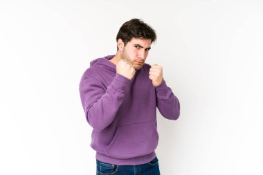 Beyaz arka planda izole edilmiş genç bir adam kameraya yumruğunu gösteriyor, agresif yüz ifadesi..