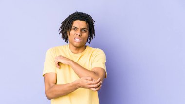 Genç Afrikalı Amerikalı Rasta adam dirsek masajı yapıyor, kötü bir hareketin ardından acı çekiyor..