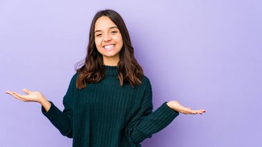 Genç, melez, Latin bir kadın. Hoş bir yüz ifadesi sergiliyor..