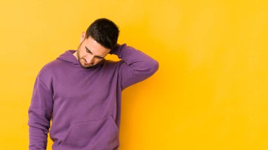 Kafkasyalı genç adam sarı fırında izole edilmiş. Stres yüzünden boynu ağrıyor. Masaj yapıyor ve elle dokunuyor..