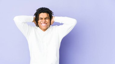 Genç Afro-Amerikan Rasta adam kulaklarını elleriyle kapatıyor yüksek sesle ses duymamaya çalışıyor..