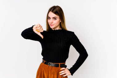 Beyaz arka planda izole genç beyaz kadın baş parmağını aşağı gösteriyor, hayal kırıklığı konsepti.