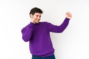 Genç adam beyaz arka planda yalnız dans ediyor ve eğleniyor..