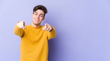 Mor arka planda izole edilmiş genç beyaz adam öne bakan neşeli gülücükler.