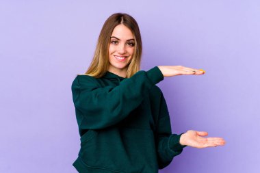 Mor arka planda izole edilmiş beyaz bir kadın iki eliyle bir şey tutuyor, ürün sunumu..