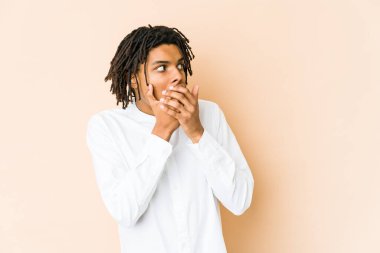 Genç Afro-Amerikan Rasta adam düşünceli bir şekilde bir fotokopi odasına bakıyor ağzını eliyle kapatıyor..