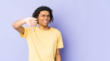 Genç Afrikalı Amerikalı Rasta adam baş parmağını aşağı gösteriyor ve hoşlanmadığını ifade ediyor..