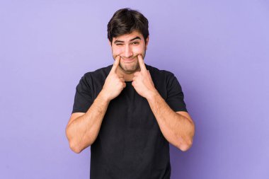 Mor arka planda iki seçenek arasındaki şüpheyle izole edilmiş genç adam.