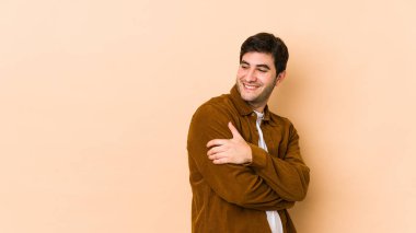 Bej arka planda yaşayan genç adam gülüyor ve eğleniyor..