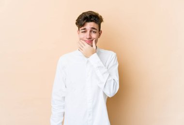 Beyazlı genç bir adam bej arka planda iki seçenek arasında kuşkulanıyor..