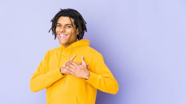 Genç Afro-Amerikan Rasta Adam 'ın dost canlısı bir ifadesi var. Avuçlarını göğsüne bastırıyor. Aşk konsepti.