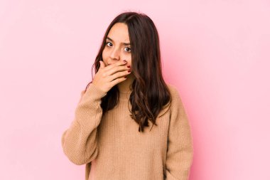 Genç, melez, İspanyol bir kadın. Ağzı kapalı, elleri endişeli görünüyor..