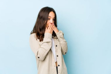 Latin kökenli genç bir kadın bir şeylere gülüyor, elleriyle ağzını kapatıyor..