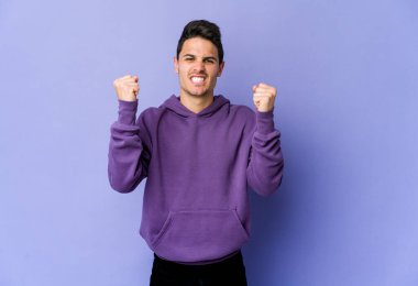 Mor arka planda izole edilmiş genç beyaz adam gergin ellerle çığlık atıyor..