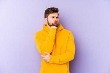 Mor arka planda izole edilmiş genç bir adam şüpheli, belirsiz, seni muayene ediyor..