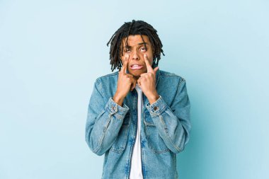 Kot ceket giyen genç siyah bir adam ağlıyor. Acı ve kafa karışıklığı gibi bir şeyden mutsuz..