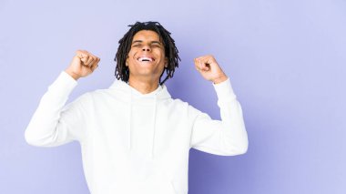 Genç Afrikalı Amerikalı Rasta adam zaferi, tutkuyu ve coşkuyu kutluyor, mutlu bir ifade..