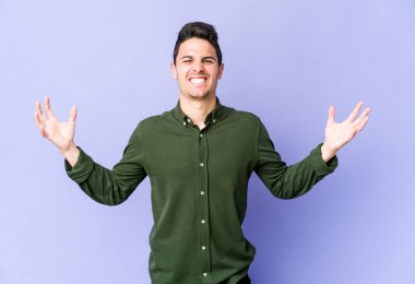 Mor arka planda izole edilmiş genç beyaz adam öfkeyle bağırıyor..