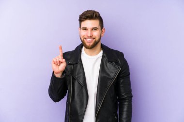 Mor arka planda izole genç bir adam parmak ile bir numara gösteriyor.