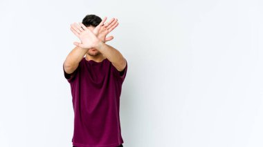 Beyaz arka planda izole genç beyaz adam iki kolu çapraz tutuyor, inkar kavramı.