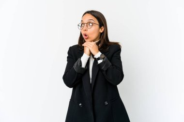 Genç melez iş kadını beyaz arka planda izole edilmiş şans için dua ediyor, şaşırmış ve ağzı açık bir şekilde önüne bakıyor..