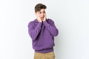 Beyaz arka planda izole edilmiş genç beyaz adam korkmuş ve korkmuş..