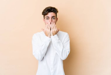 Beyazlı genç bir adam bej arka planda izole edildi..