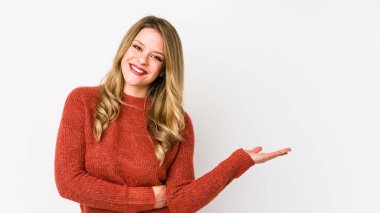 Beyaz arka planda izole edilmiş genç beyaz kadın bir avuç içinde fotokopi alanı ve belinde bir el daha gösteriyor..