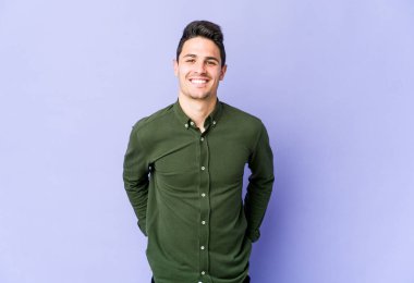 Mor arka planda izole edilmiş genç beyaz adam mutlu, güler yüzlü ve neşeli..