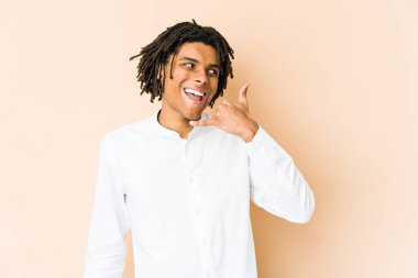Genç Afrikalı Amerikalı Rasta adam cep telefonu hareketini parmaklarıyla gösteriyor..