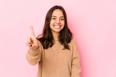 Genç, melez, Latin bir kadın bir numarayı parmağıyla gösteriyor..