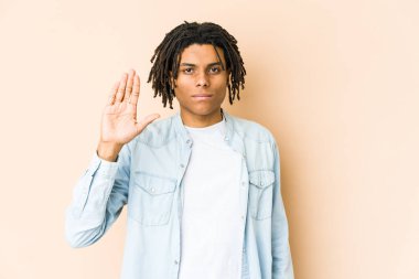 Genç Afrikalı Amerikalı Rasta adam gülümseyerek beş numarayı parmaklarıyla gösteriyor..