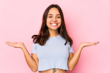 Genç, melez İspanyol bir kadın soyutlanmış, kollarıyla ölçek yapıyor, mutlu ve kendinden emin hissediyor..