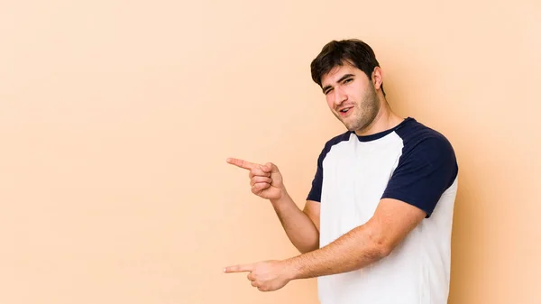 Joven Aislado Sobre Fondo Beige Señalando Con Los Dedos Delanteros — Foto de Stock