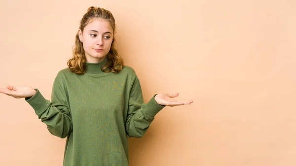 Jonge Blanke Vrouw Geïsoleerd Beige Achtergrond Verward Twijfelachtige Schouders Een — Stockfoto