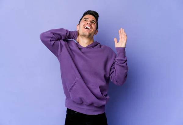 Young caucasian man isolated on purple background screaming with rage.
