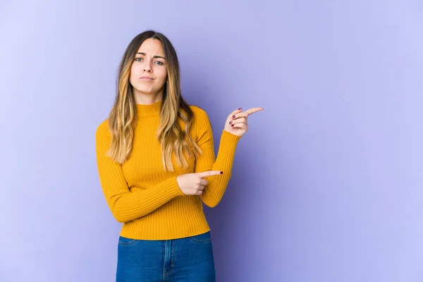 Mujer Joven Caucásica Aislada Sobre Fondo Púrpura Conmocionada Señalando Con — Foto de Stock